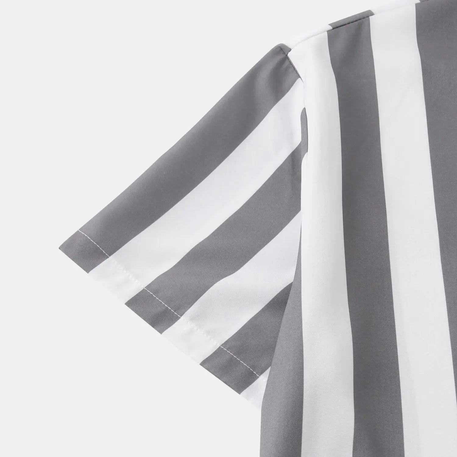 Chemise pour homme à rayures, à manches courtes, boutonnée sur le devant, avec des rayures verticales grises et blanches marquées et une couture propre le long de l’ourlet de la manche.
