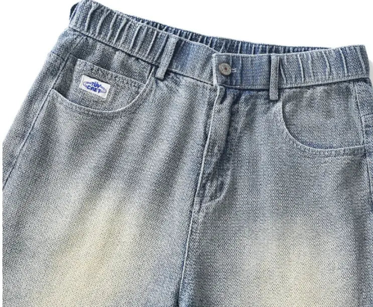 Men’s elastic waist light wash denim shorts featuring a relaxed fit with subtle fading from blue to beige.