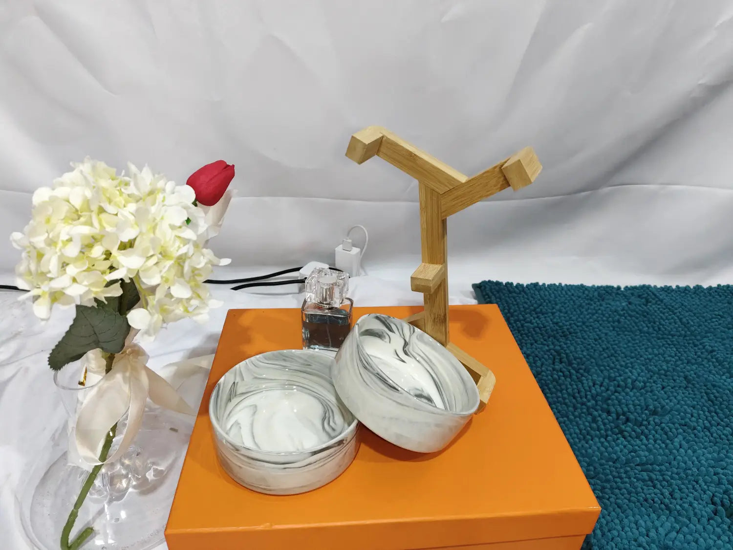 marble-patterned ceramic round bowls in a ceramic double pet bowl with wood stand displayed on an orange box