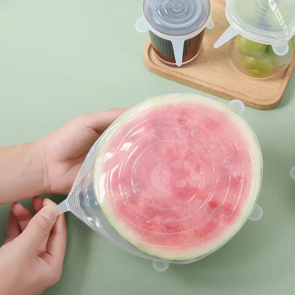 Transparent silicone stretch lid from 6-pack reusable silicone stretch lids covering a watermelon slice for food storage