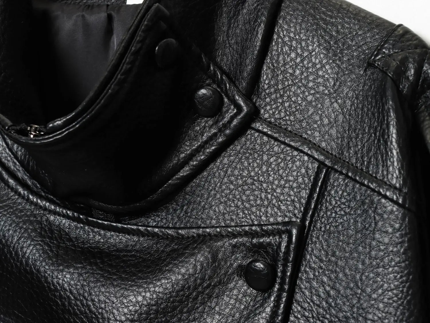 Schwarze Damen-Motorradjacke mit hohem Stehkragen aus Kunstleder mit strukturierter Oberfläche und Druckknöpfen.