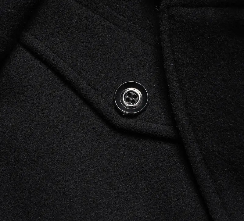 a sleek silver four-hole button on the black wool fabric of a men wool winter overcoat quilted jacket