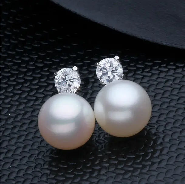 Elegant white pearl and cubic zirconia silver stud earrings featuring a lustrous white pearl base and sparkling clear gemstones set in silver-toned metal.