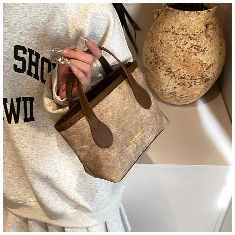 Beige canvas mini tote with brown leather handles and trim from the retro bucket bag textured canvas shoulder handbag collection.