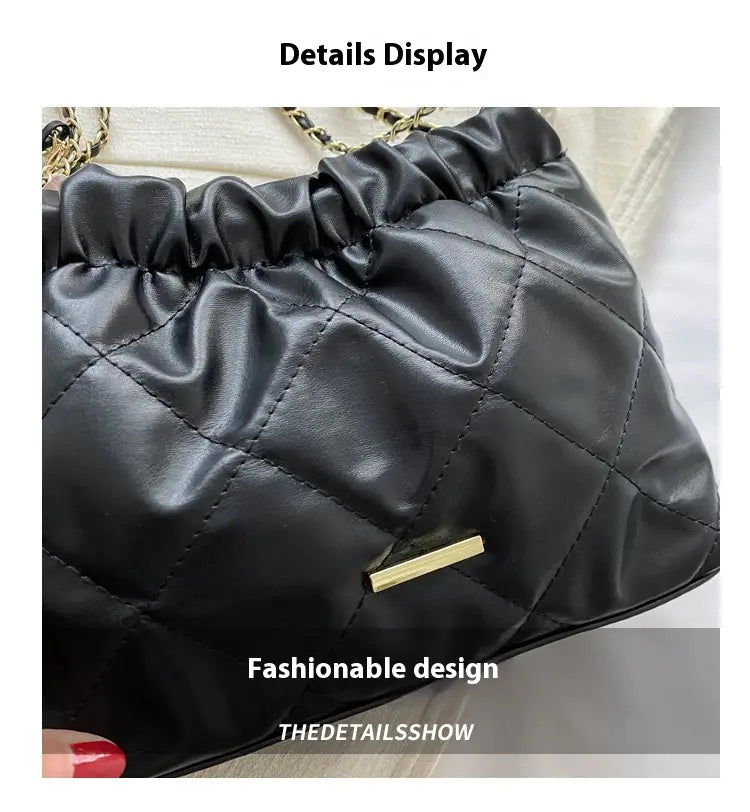 Black quilted faux leather crossbody bag with a shiny satin-like finish and gold-tone chain strap hardware.