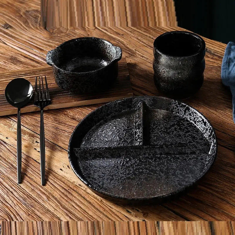 Assiette de dîner divisée en céramique noire texturée à mouchetures, avec glaçure à mouchetures et une conception en sections pour des repas portionnés.