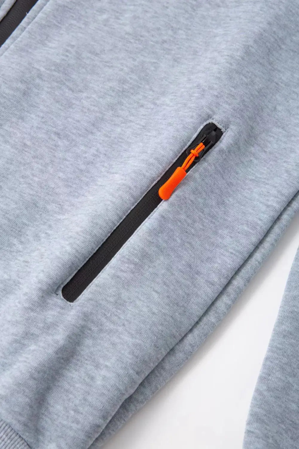 Sudadera deportiva con cierre para hombre en tallas grandes en tejido jaspeado gris, con cremallera negra y lengüeta de extracción color naranja brillante, diseñada para uso atlético