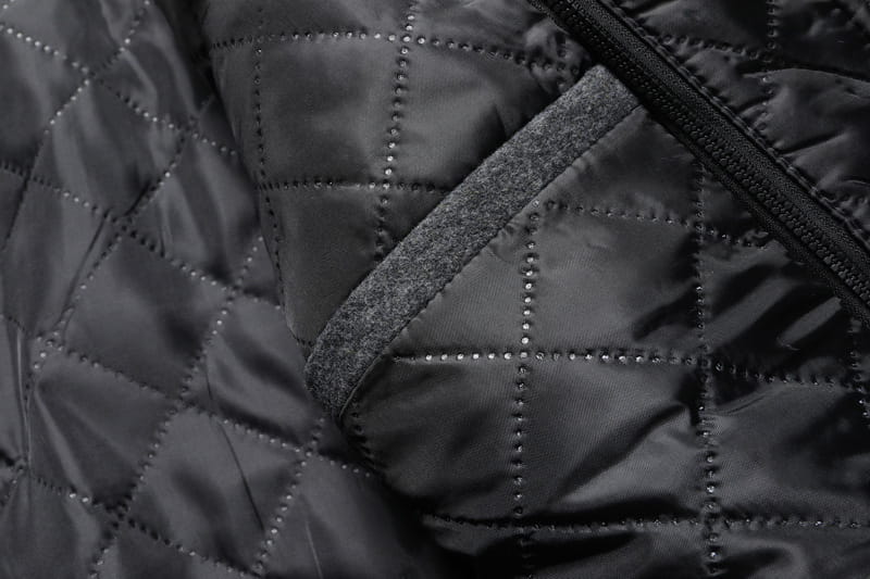 Men wool winter overcoat quilted jacket in black with a subtle sheen diamond-stitched pattern and contrasting gray fabric lining along the zipper.