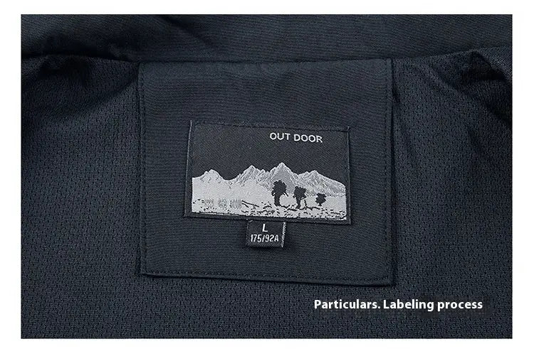 Black fabric label with embroidered mountain and hiker design featuring outdoor text and size information on a men casual lightweight outdoor windbreaker jacket.