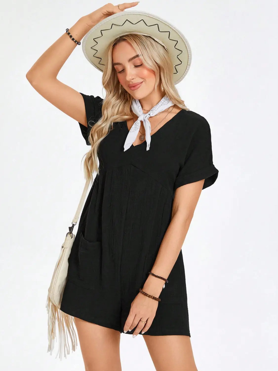 Black cotton batwing sleeve pocket romper with short sleeves v-neckline and front pockets accessorized with a white bandana tied at the neck.