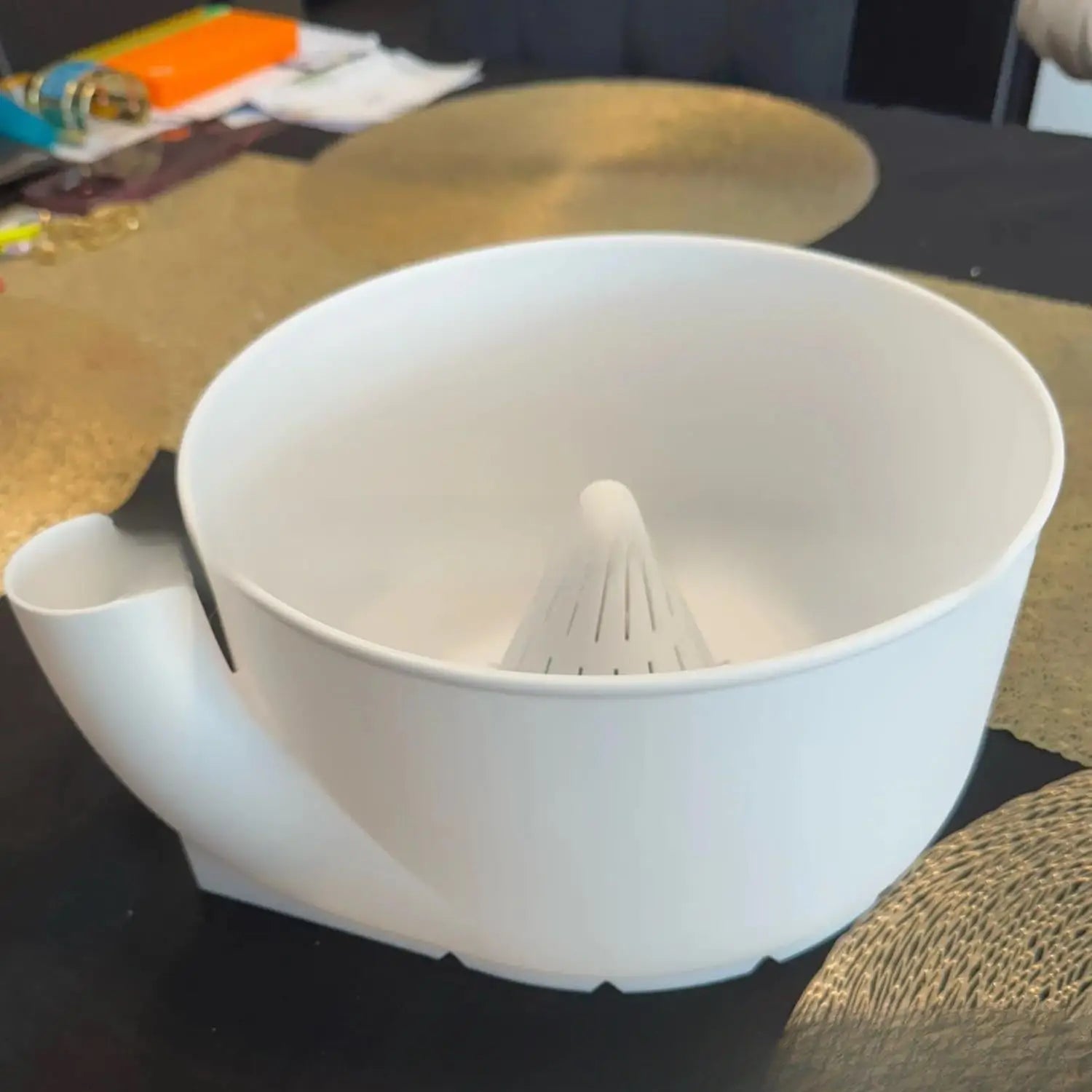 Presse-agrumes en plastique blanc, muni d’un réceptacle conique et d’un bec verseur, inclus dans un ensemble de bol de lavage de fruits et de presse-agrumes.