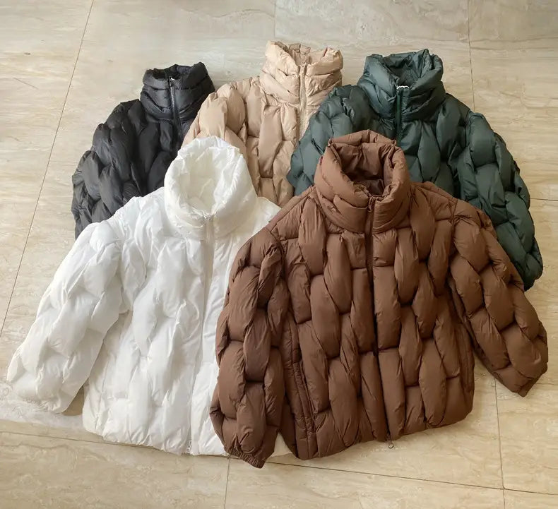 five plus size quilted puffer jackets in black beige dark green white and brown displayed on a tiled floor showcasing their insulated material and warm design