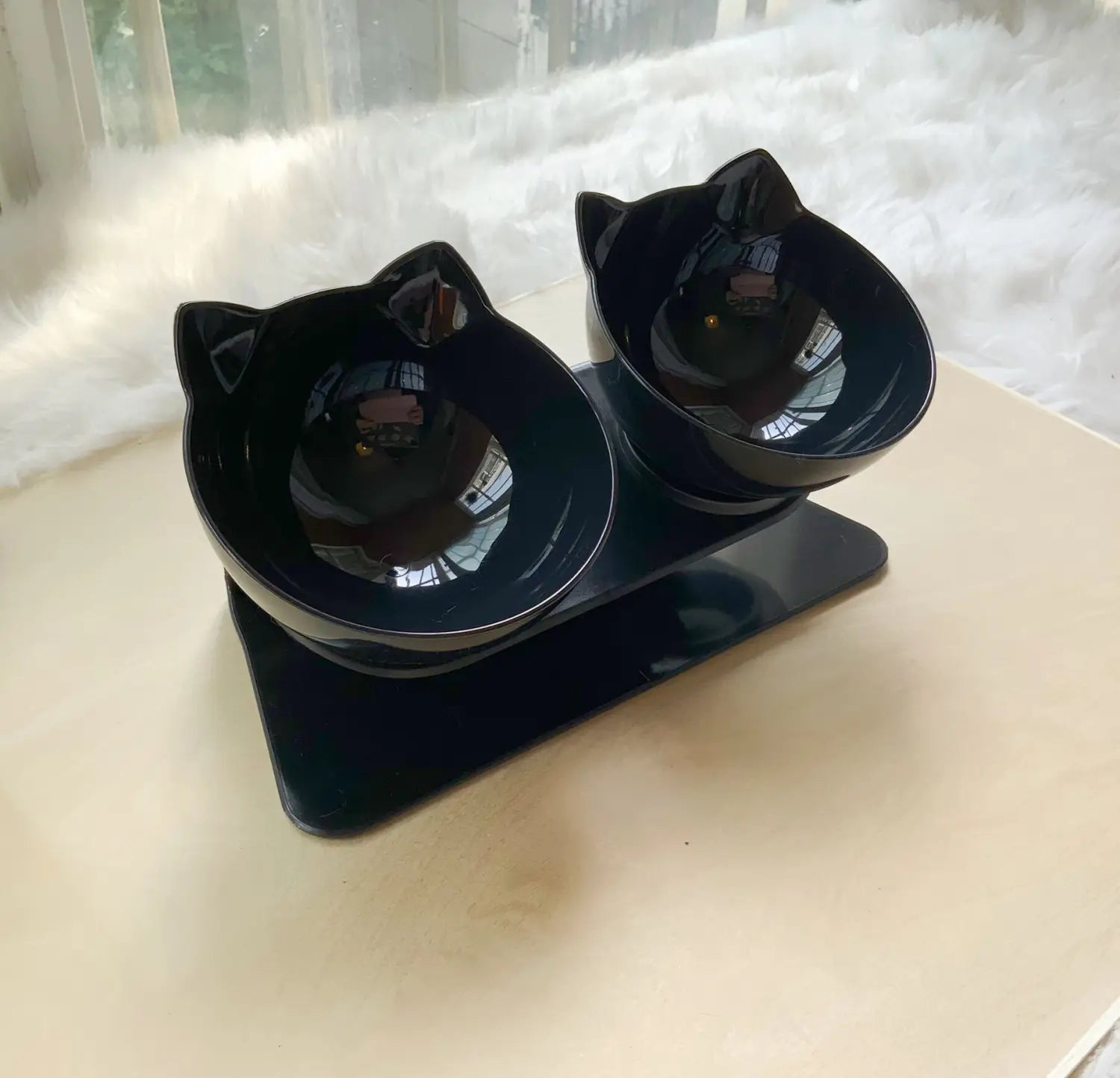 Black cat-shaped ceramic pet bowls with a glossy finish mounted on a matching black elevated base tilted at 15 degrees double feeder stand.