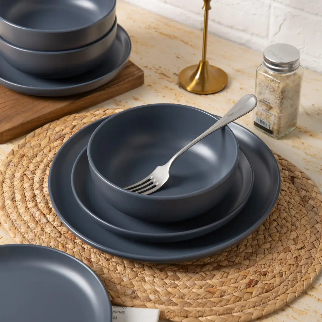 dark gray ceramic bowl with a smooth matte glaze finish and a silver fork inside part of a 12-piece stoneware dinnerware set matte glaze service for 3