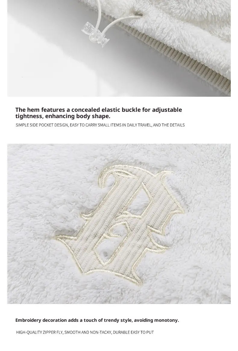 Ein weißes flauschiges Handtuch mit besticktem Monogramm-Design, neben einer warm gefütterten Cord-Pufferjacke präsentiert