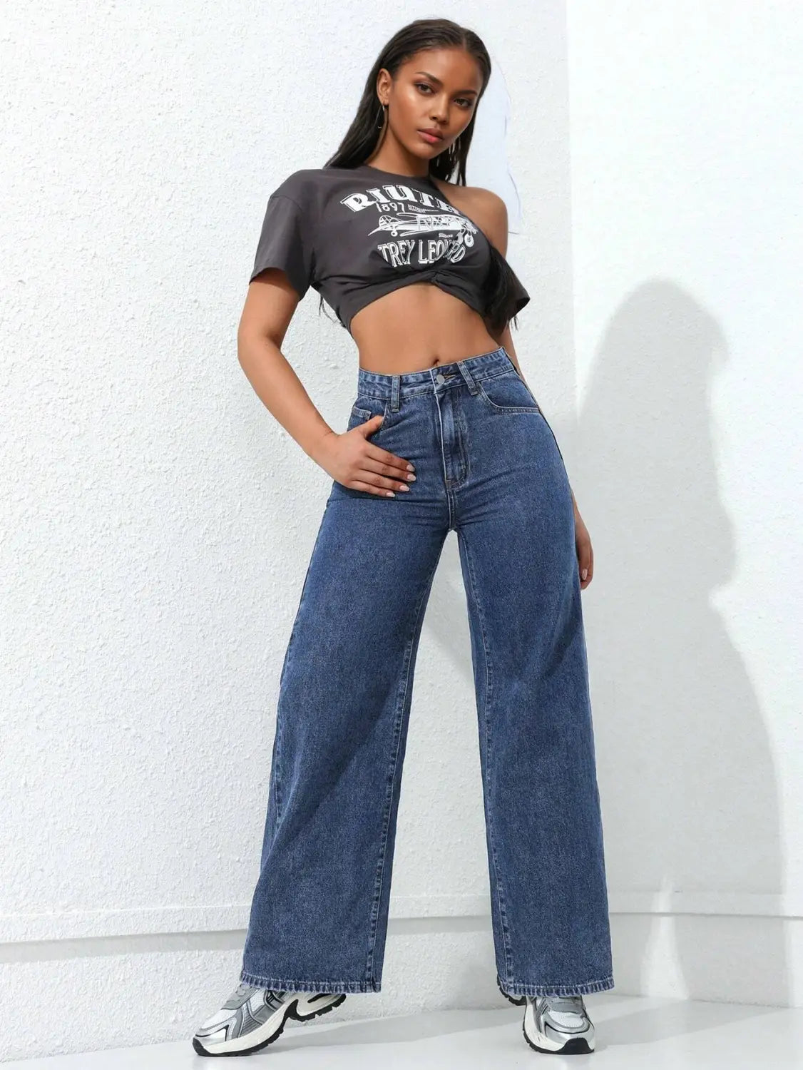 Jean à taille haute, jambe large et évasée, en denim bleu, à coupe droite, présenté de face.