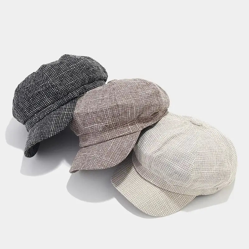 Three textured British style tweed octagonal caps for women in black beige and light gray with a woven fabric finish.