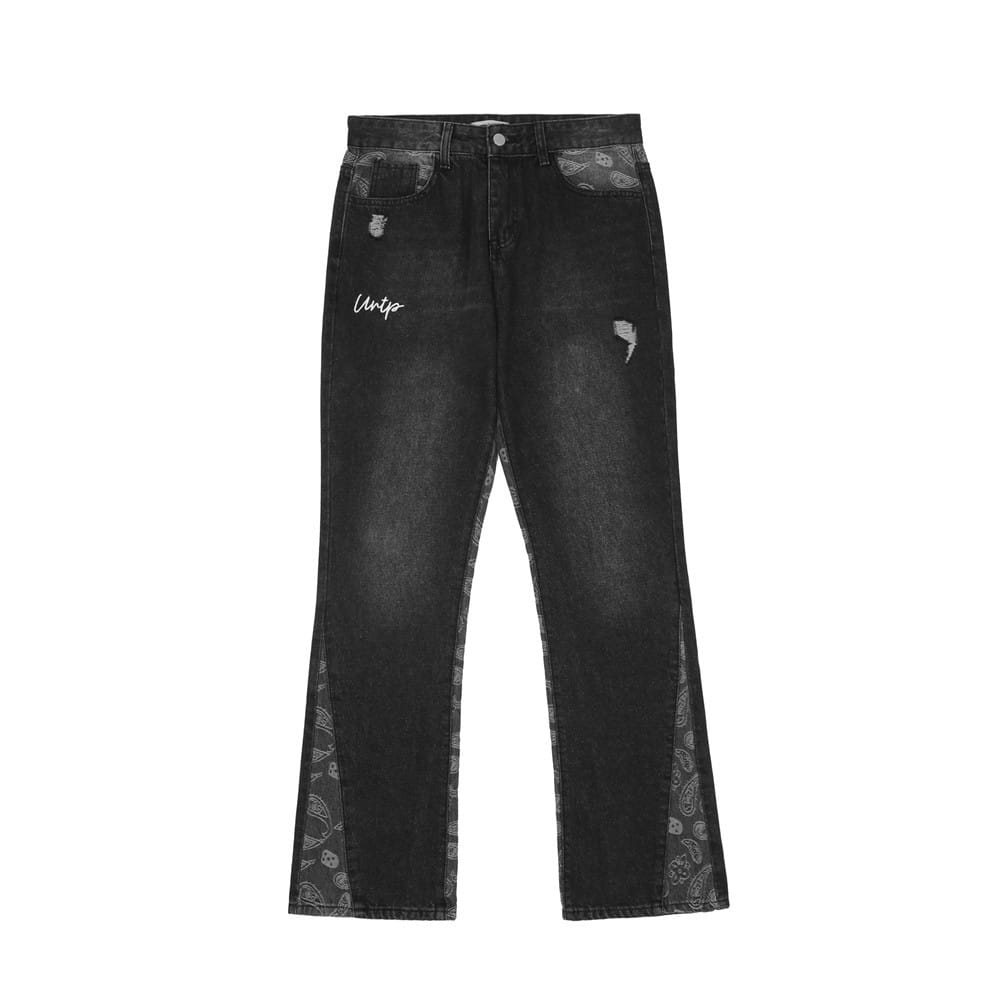 Men’s black denim distressed paisley patchwork flare jeans featuring a faded wash with bandana patterned side panels and subtle white embroidery on the thigh.