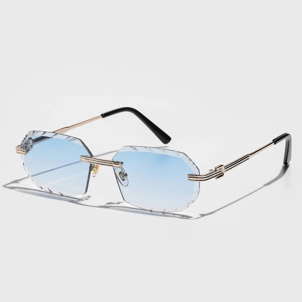 Rahmenlose geometrische Diamant-Schnitt-Gradienten-Sonnenbrille mit goldfarbenen Metallfassungen, hellblauen Gradientenlinsen und schwarzen Bügelspitzen.