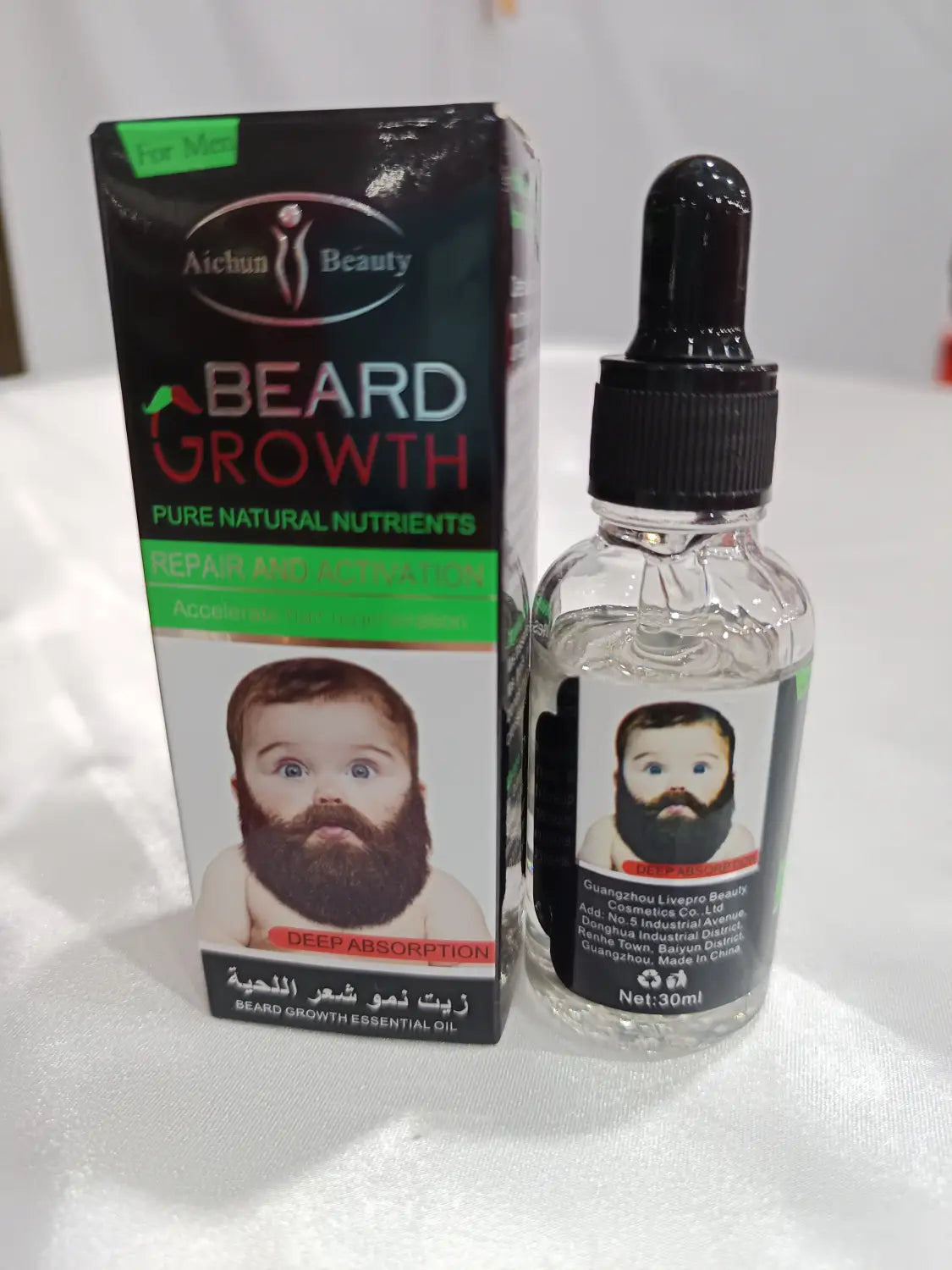 Clear glass bottle with black dropper cap and label featuring a babys face containing beard growth oil for natural repair and nourishing care.