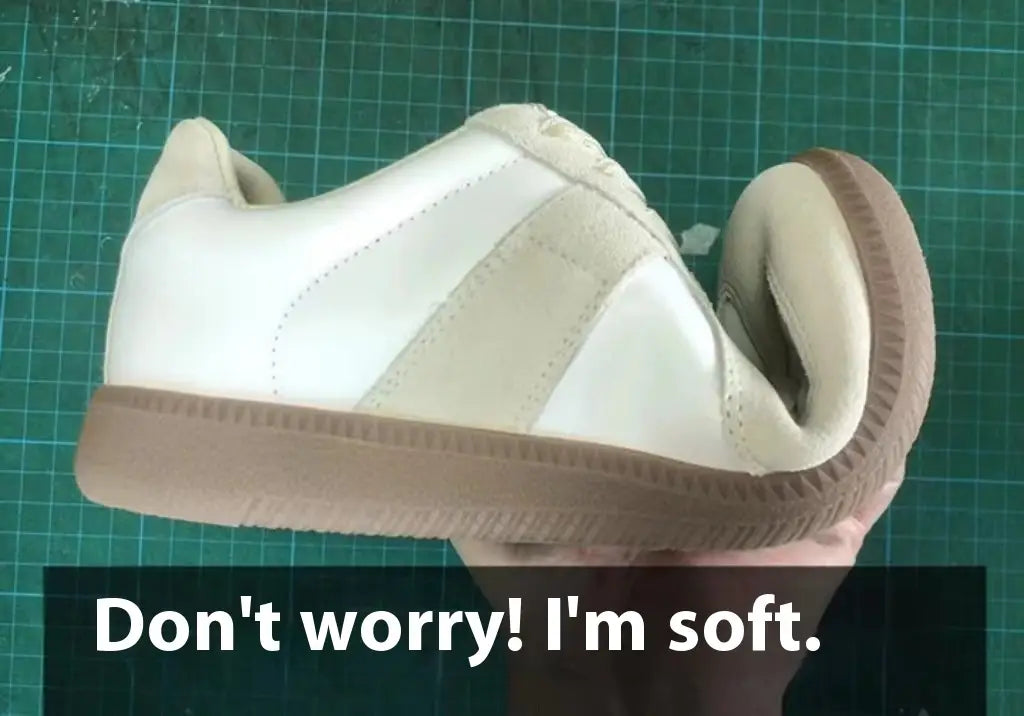 Ein weißer und beiger Ledersneaker mit einer weich gepolsterten Sohle, ausgelegt als vielseitiger Freizeitschuh im Low-Top-Design.