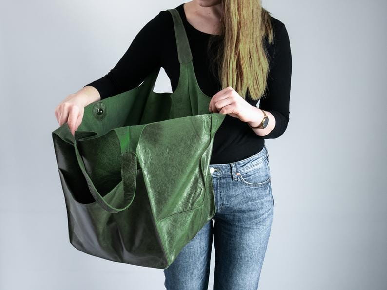 Olive green leather tote bag with large capacity soft slouchy shoulder design featuring a contrasting black interior and sturdy handles.