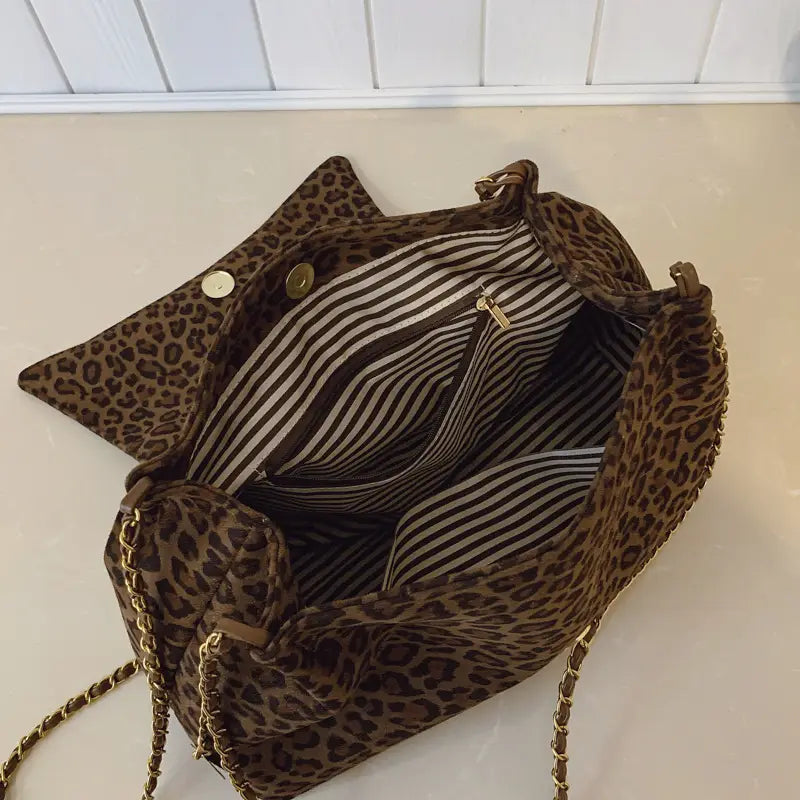 Leopard print crossbody bag in brown velvet with gold-tone chain strap and striped interior lining.