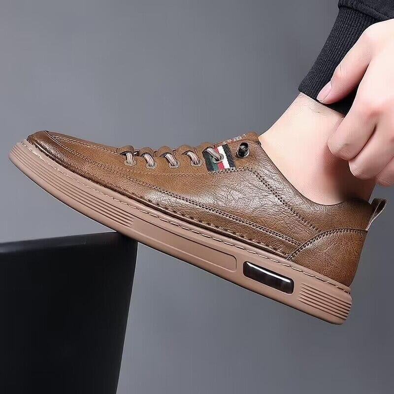 Brauner Ledersneaker im Casual-Stil mit strukturierter Oberfläche und beiger Gummisohle, mit Luftpolsterung und horizontalen Rillen für gepolstertes Freizeit-Sportoutfit.