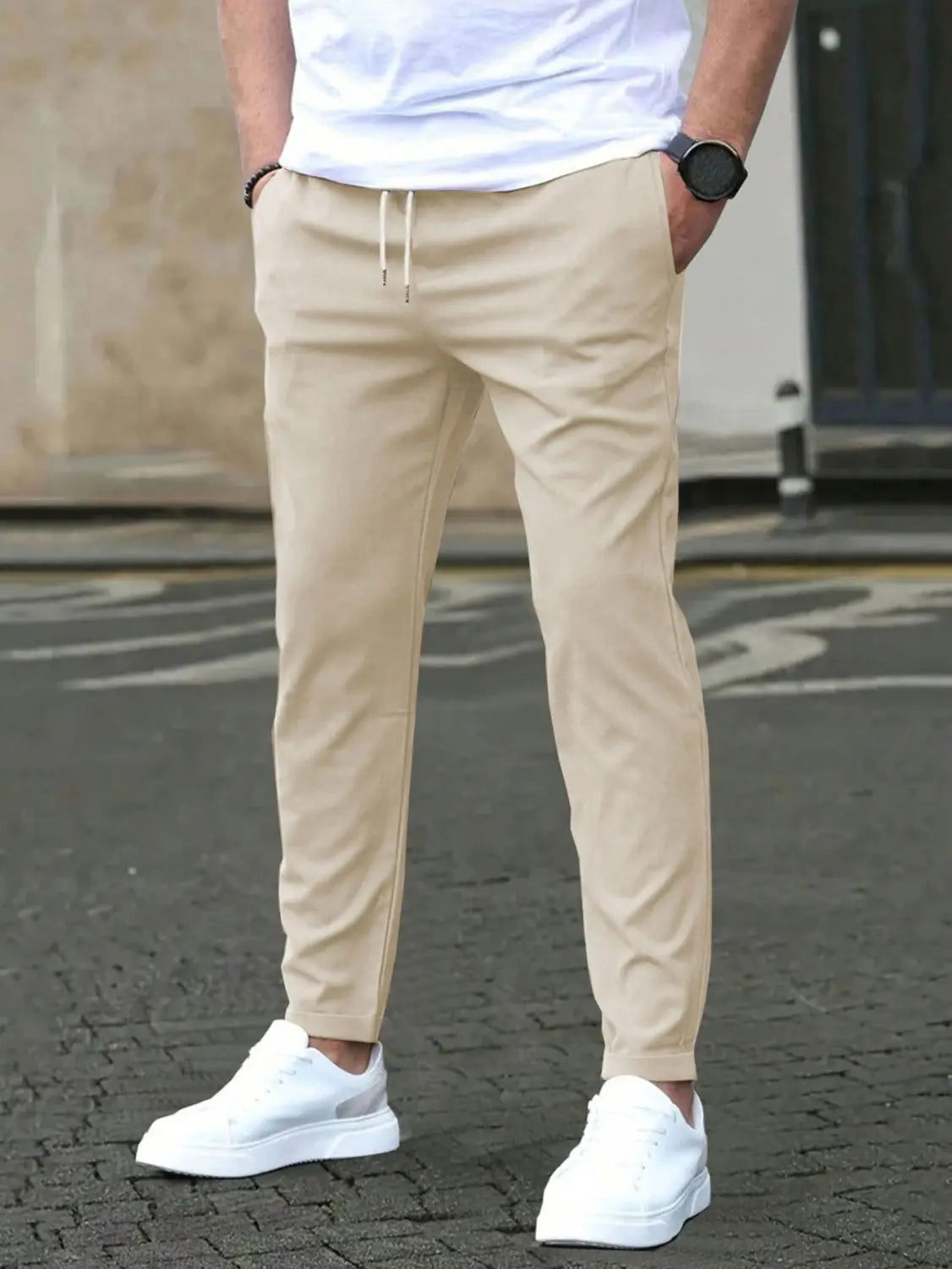 Beige slim fit tapered jogger pants with drawstring featuring a relaxed fit and tapered legs.