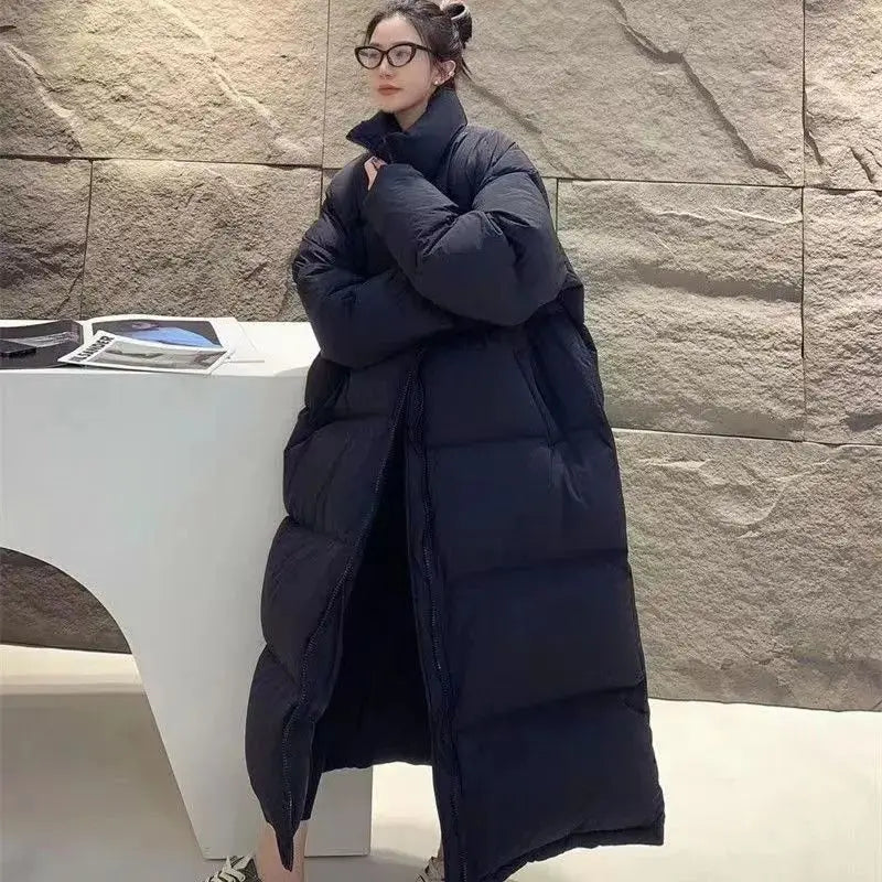 A long black quilted puffer coat with a high collar made of cotton designed as a winter jacket for women.