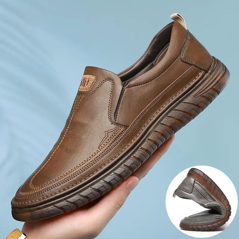 Men’s breathable non slip gray leather slip-on loafers with textured sole and visible stitching.