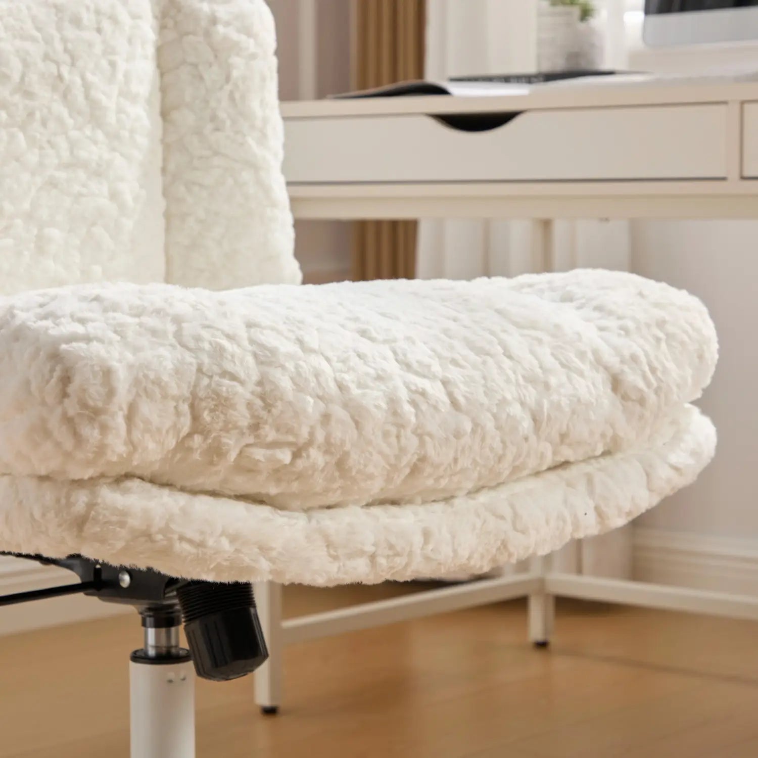 Chaise de bureau en fausse fourrure blanche et duveteuse, avec texture matelassée et assise rembourrée, conçue comme chaise de vanité à assise large pivotante.
