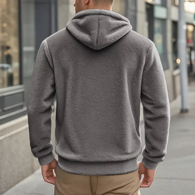 A cozy gray fleece lined men’s zip up hooded jacket with a soft plush texture and ribbed cuffs.