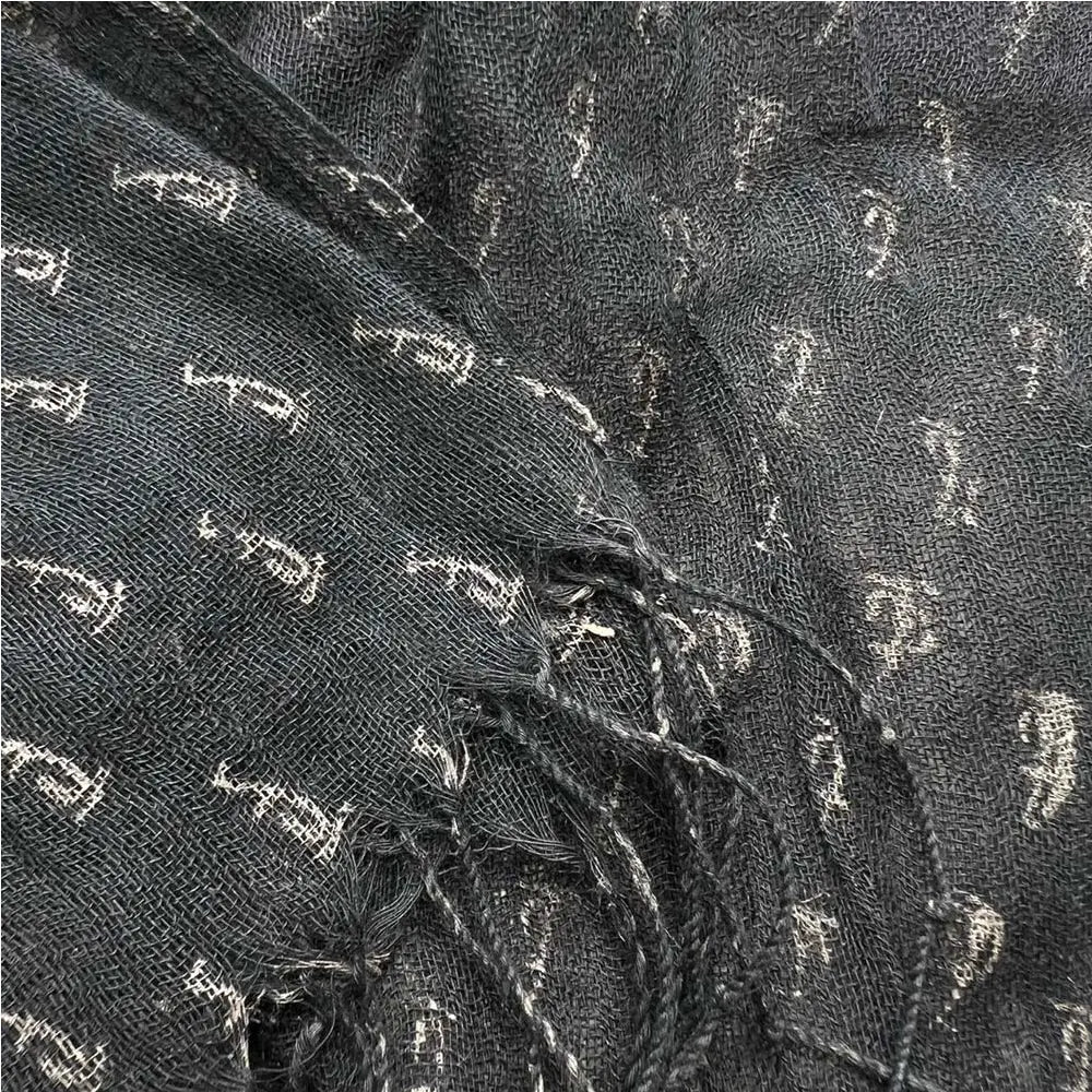 Écharpe en viscose gris foncé avec un motif blanc discret et des bords effilochés, conçue comme une élégante étole pour la soirée.