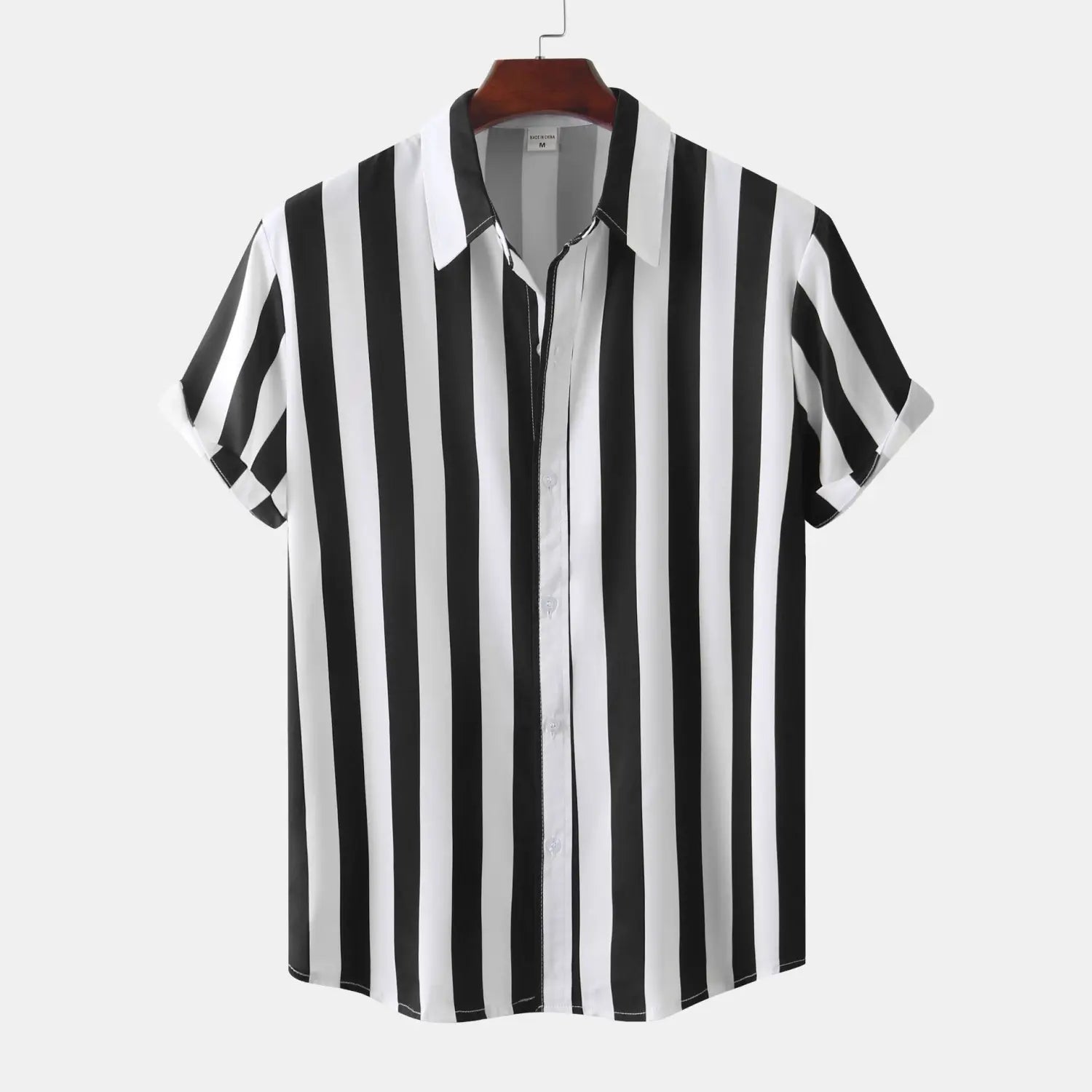 Chemise pour homme à rayures, à manches courtes, boutonnée sur le devant, aux rayures verticales noir et blanc, suspendue à un cintre en bois.