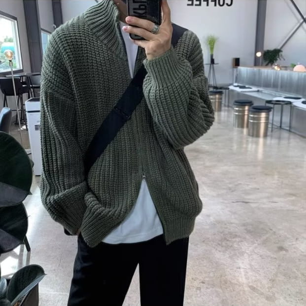 Men’s ribbed knit zip up sweater cardigan in olive green with a relaxed fit and front zipper closure.