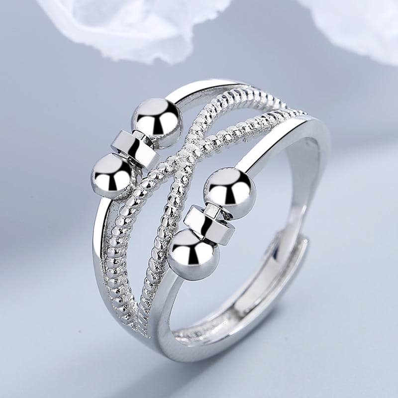 interwoven silver anxiety relief adjustable ring with three interwoven bands featuring polished spherical beads and textured detailing in silver.