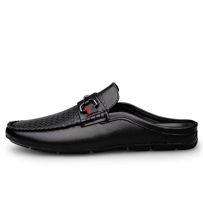 Black leather men’s mule loafers with woven texture on the upper and metallic buckle accent.
