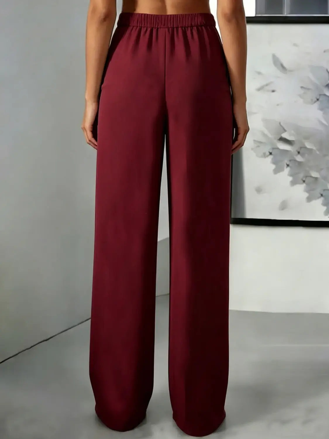 Pantalons à jambes larges bordeaux avec une ceinture élastique à taille haute et un tissu plissé lisse et fluide.