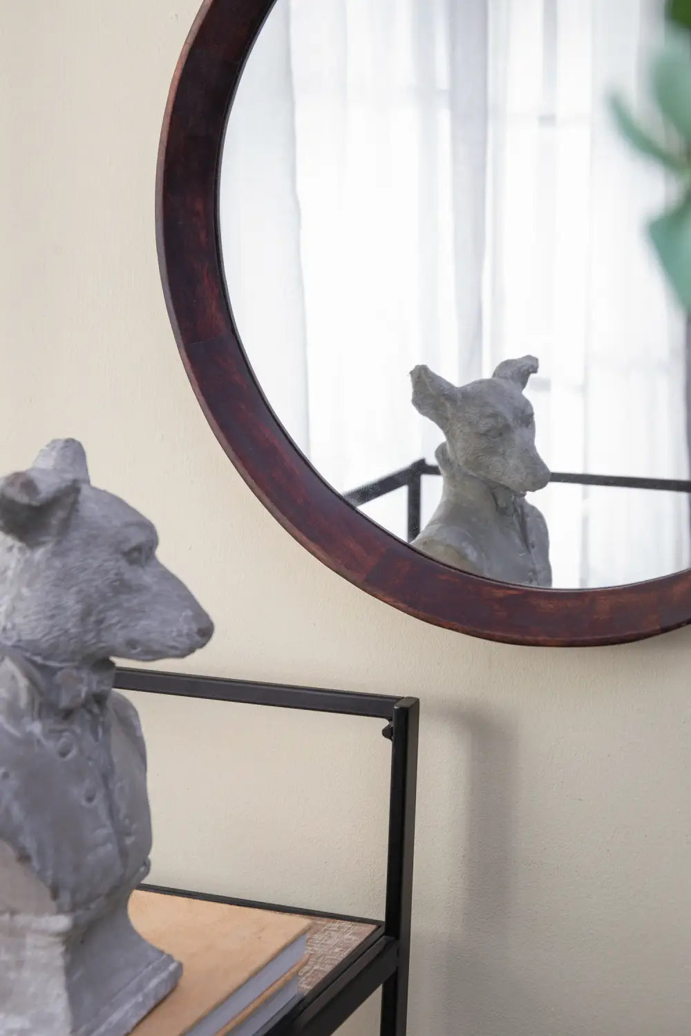 gray stone dog bust sculpture with textured surface and detailed facial features alongside mango wood round wall mirror 20 inch with dark bronze frame