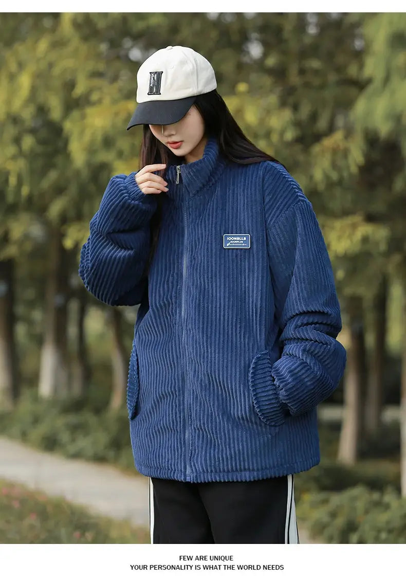 Blaue Herren Cord-Pufferjacke mit gerippter Struktur und Reißverschluss vorne sowie kleinem rechteckigem Aufnäher auf der linken Brust, entworfen für winterliche Wärme.