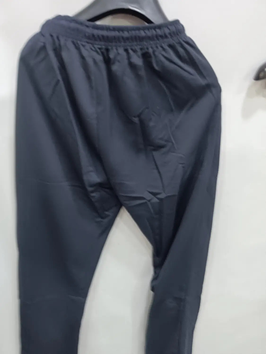Men breathable quick dry mesh joggers in black featuring elastic waist and tapered legs with smooth slightly shiny fabric.