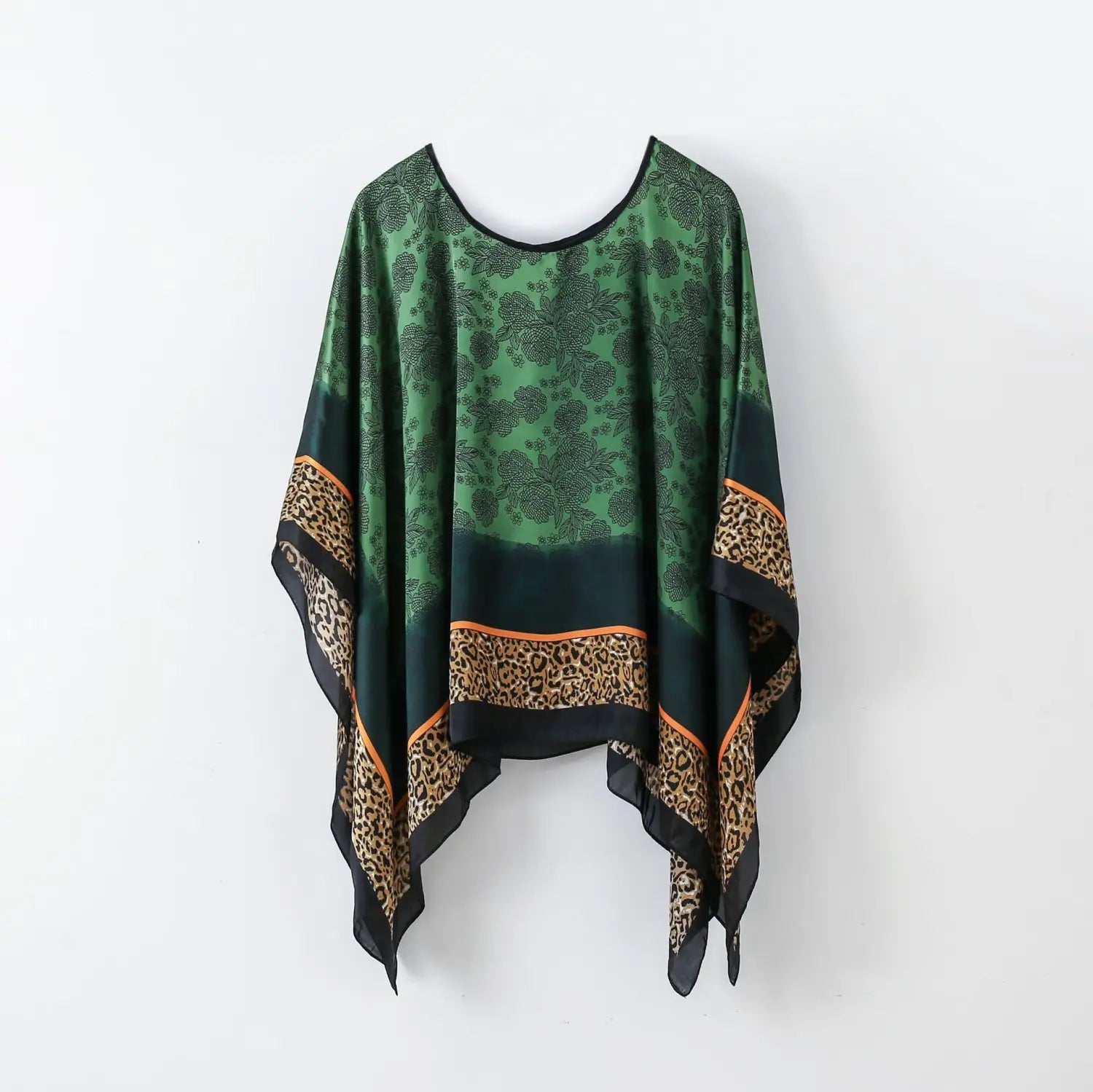 A flowing green and black leopard-print printed silk patterned pullover shawl cape outerwear with a floral pattern and orange trim along the edges.