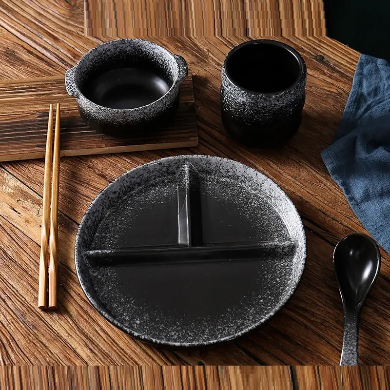 Assiette de dîner divisée en céramique noire à mouchetures, avec glaçure à mouchetures et trois compartiments pour le contrôle des portions et l’organisation des repas.