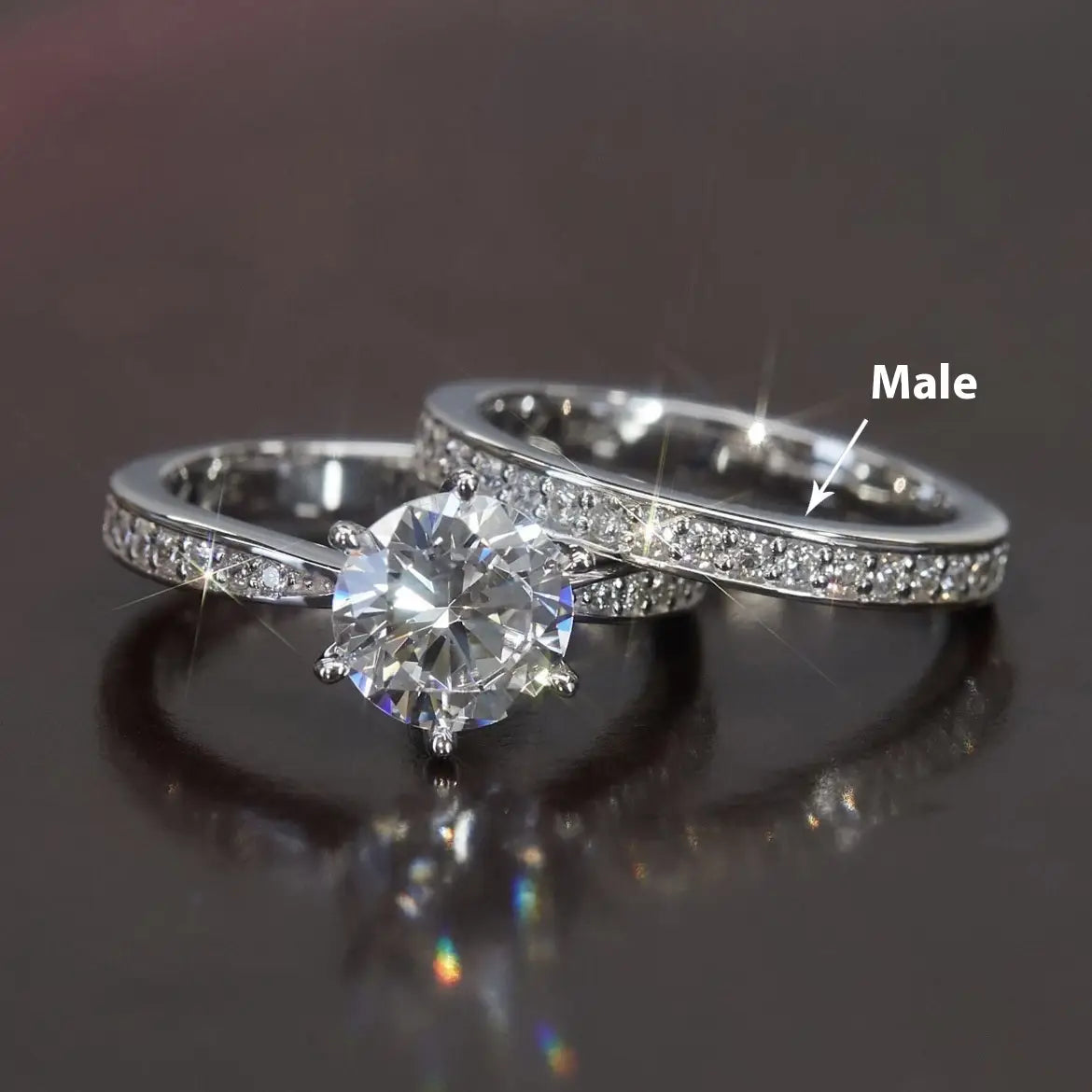 A sparkling silver round cut zircon wedding ring set in white gold finish featuring a central round-cut diamond with smaller diamonds and a matching men’s pavé-set diamond wedding band.