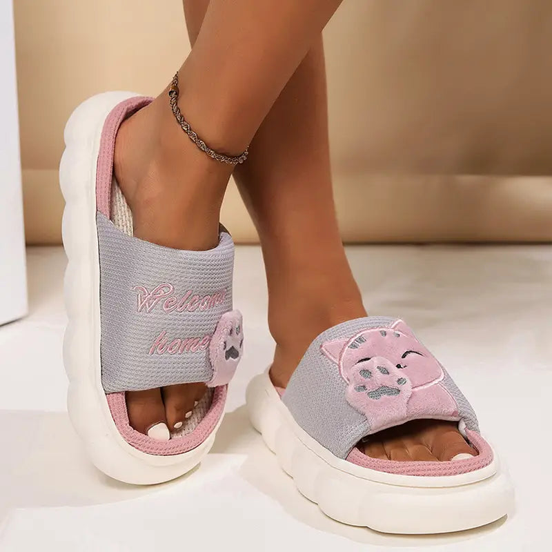 Pink and gray embroidered cat cartoon unisex anti slip slide sandals with a thick white sole.