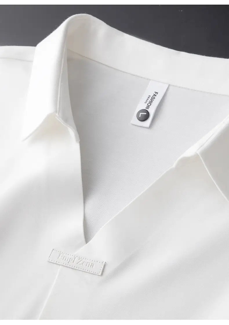 Ein Herren-Slim-Fit-Poloshirt aus weißer Baumwollmischung mit Strukturoptik; mit einem präzisen, blusenartigen Schnitt, einem eleganten Kragen und dezenten Ziernähten.