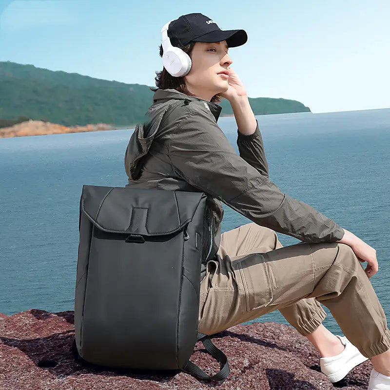 black minimalist laptop backpack with sleek flap closure and subtle side branding designed for usb charging and school use