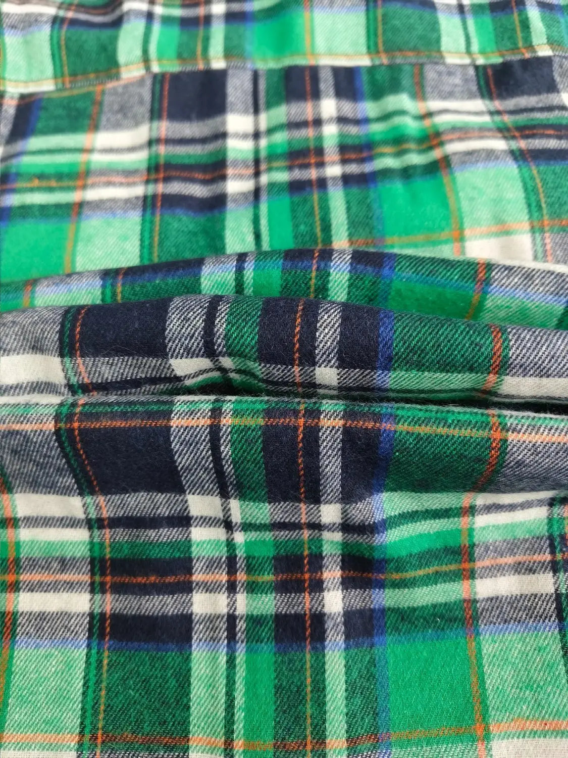 Men’s slim fit plaid flannel button up shirt featuring green, navy blue, white, and orange colors in a soft flannel fabric.