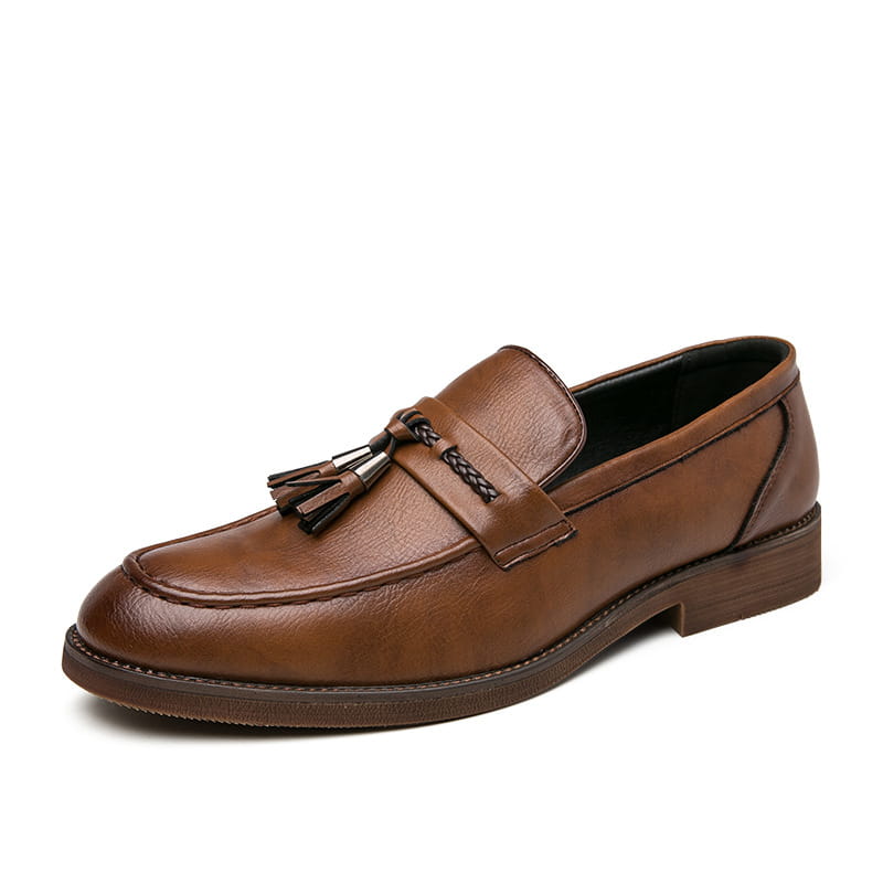 Mocasín tipo brogue para hombre en cuero marrón con borlas, detalle trenzado y suela de goma.